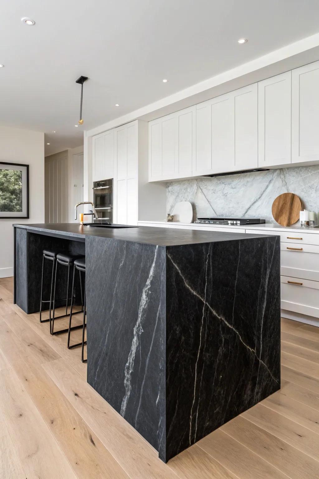 Sculptural black waterfall island adds modern drama to an airy white kitchen.
