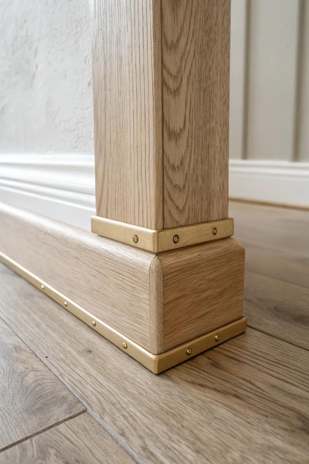 A bold brass strap “belt” turns mismatched baseboards into one intentional transition detail.