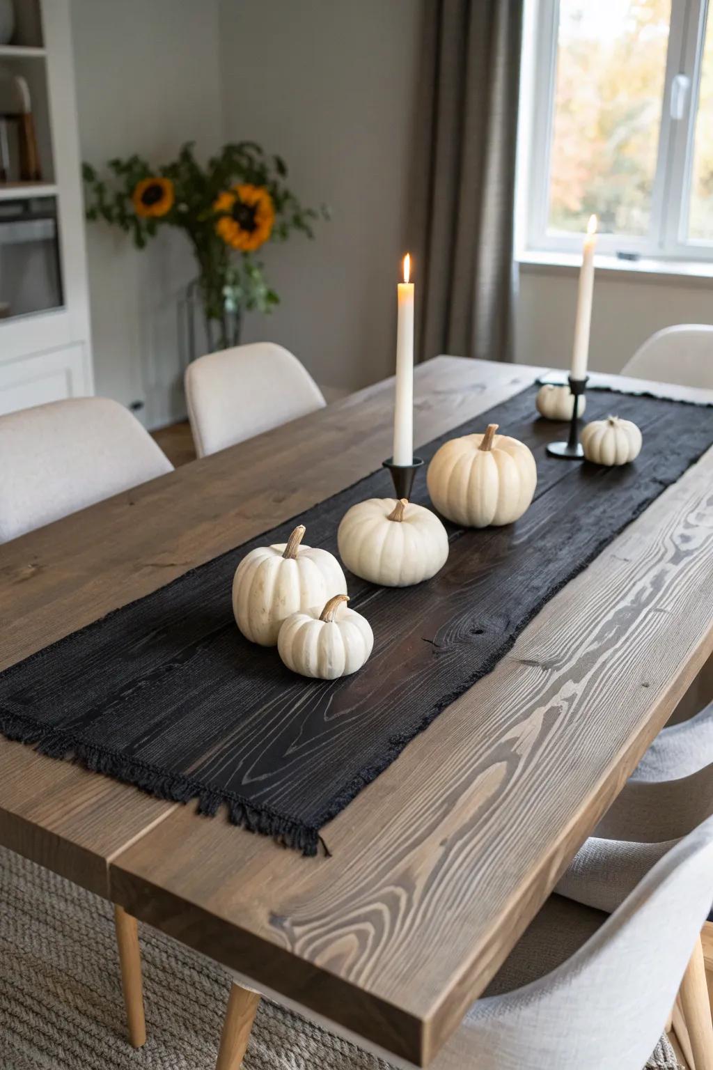 Charred wood center plank with white pumpkins and candlelight for moody fall dining.