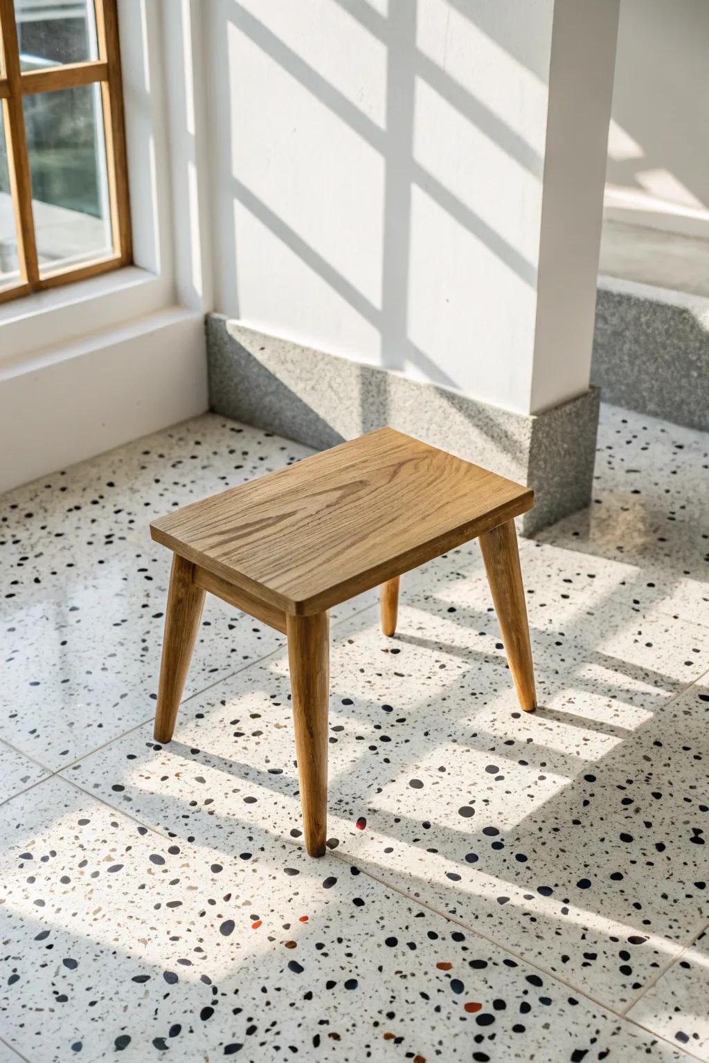 White speckled retro vinyl tile + warm oak stool: an easy mid‑century sparkle with zero fuss.