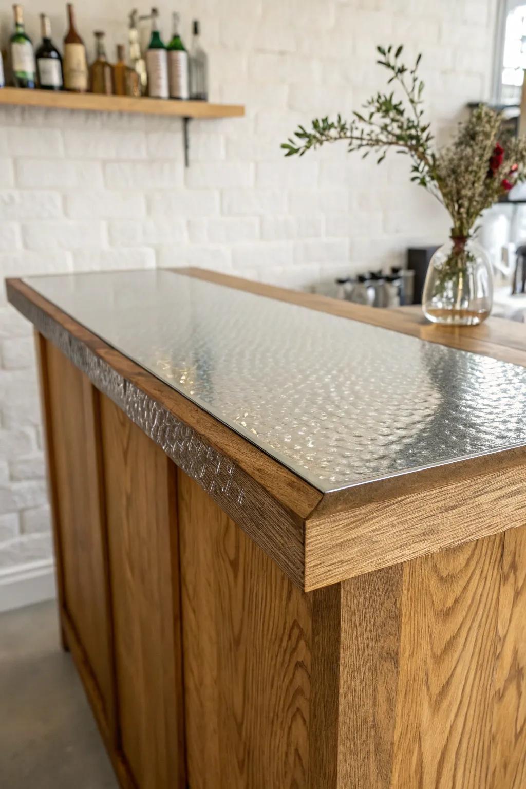 Hammered metal skin, sealed clear—an industrial bar top with warm wood edges and glow.