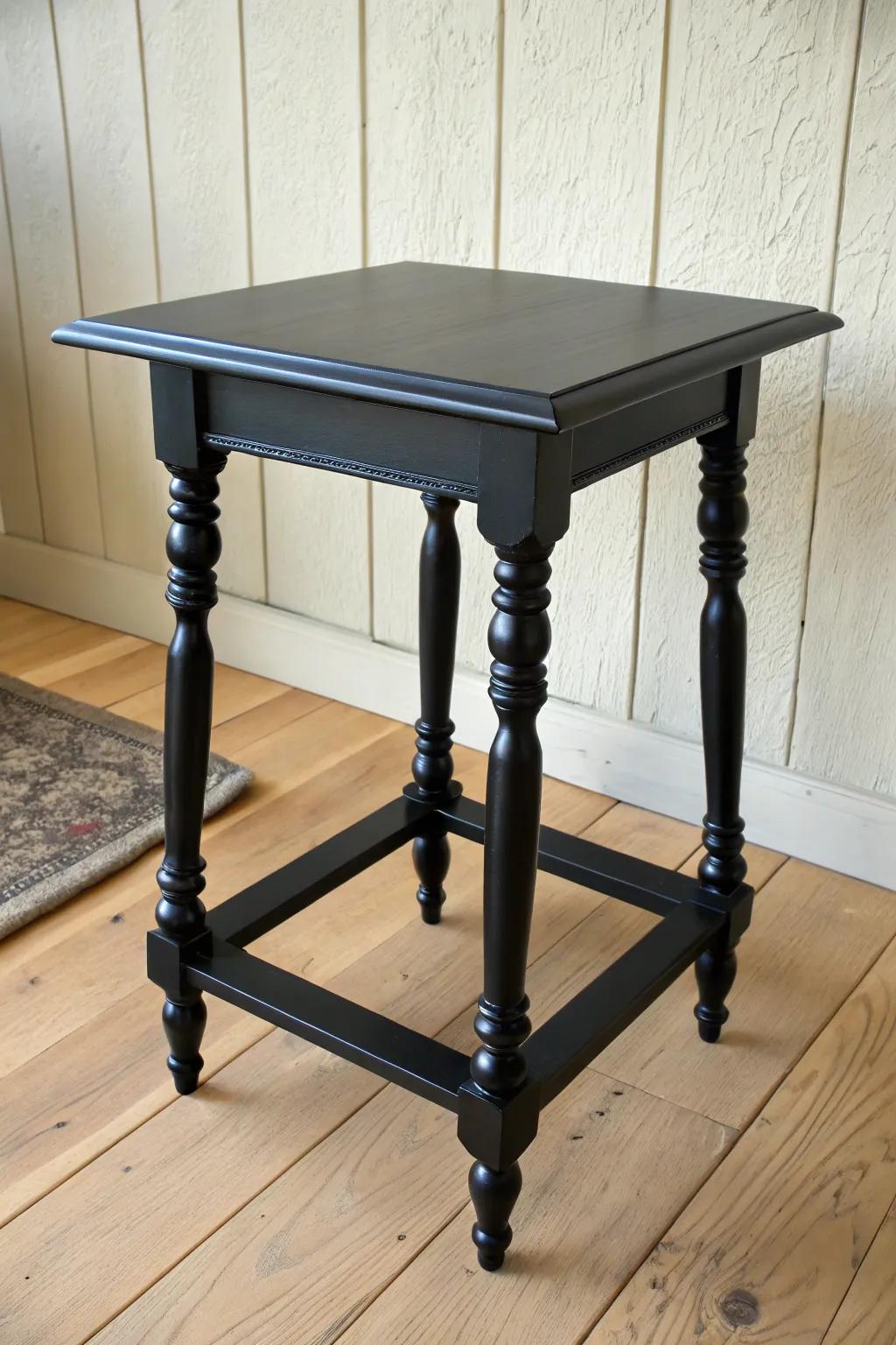 Moody true-black end table with a soft satin sheen—spindle legs pop like a silhouette.