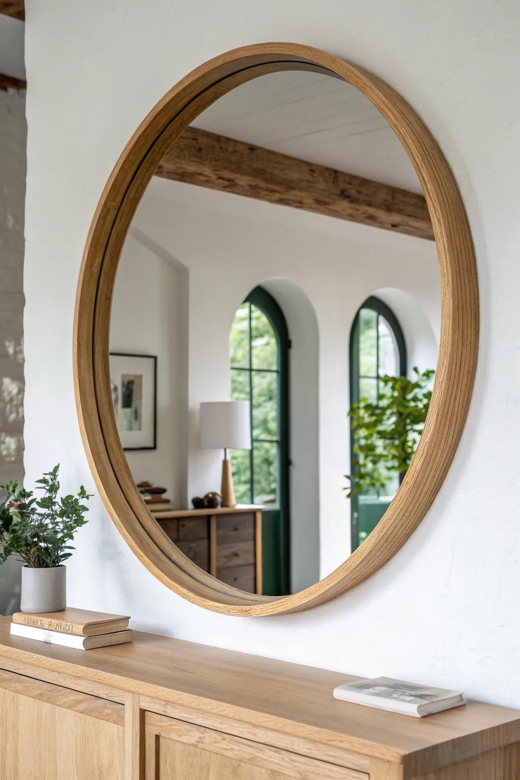 Oversized oak-framed round mirror that brightens a modern rustic entryway with airy light.