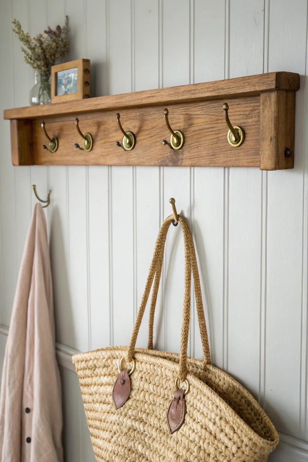 Vintage French country wall hooks: aged brass on a painted backer for calm, tidy entryway charm.