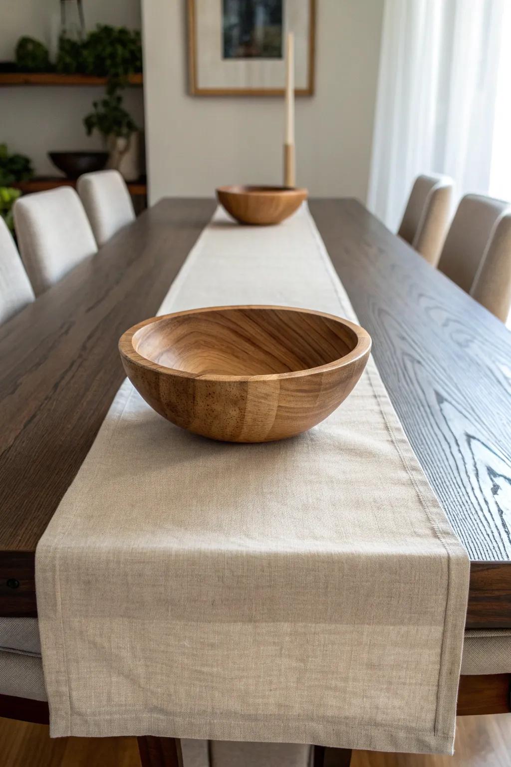 A neutral linen runner + one hand-turned wooden bowl = an effortlessly finished table.