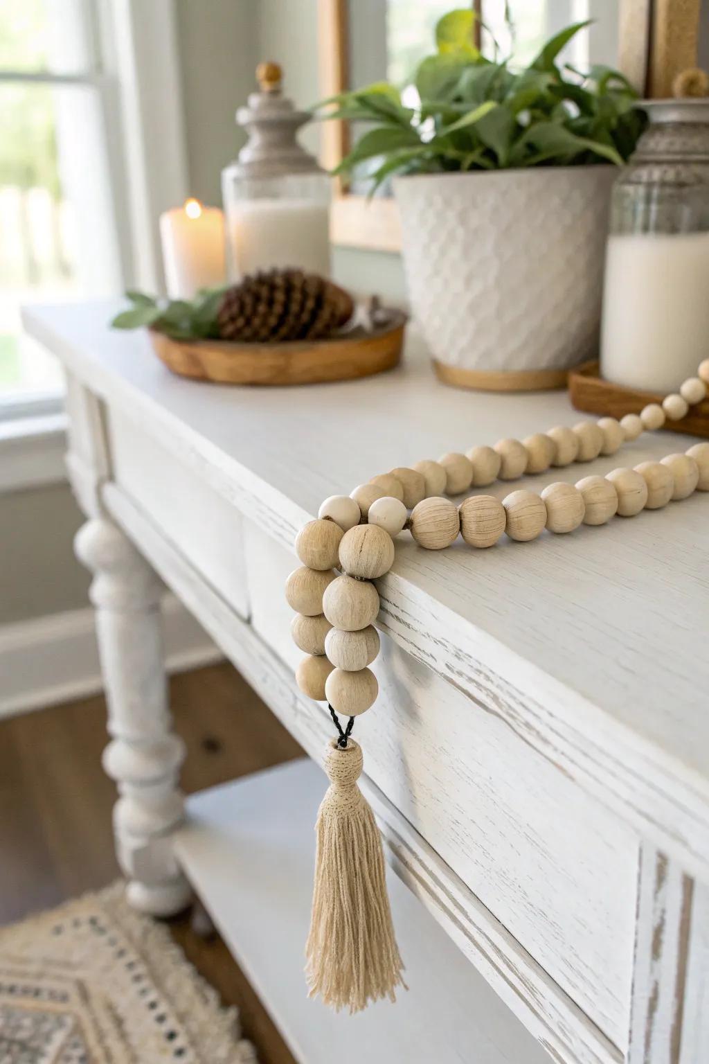 Handmade wood bead garland adds soft farmhouse warmth and contrast to a painted entry table.