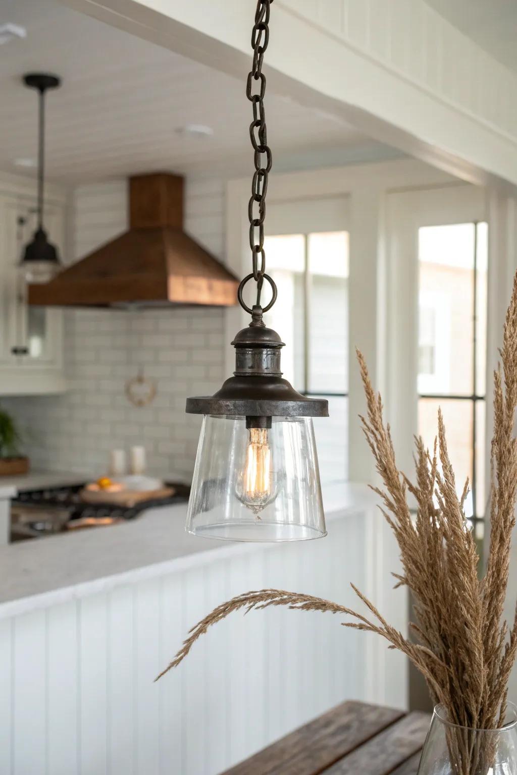 Chain-hung pendant lighting adds grounded vintage farmhouse charm above the kitchen island.
