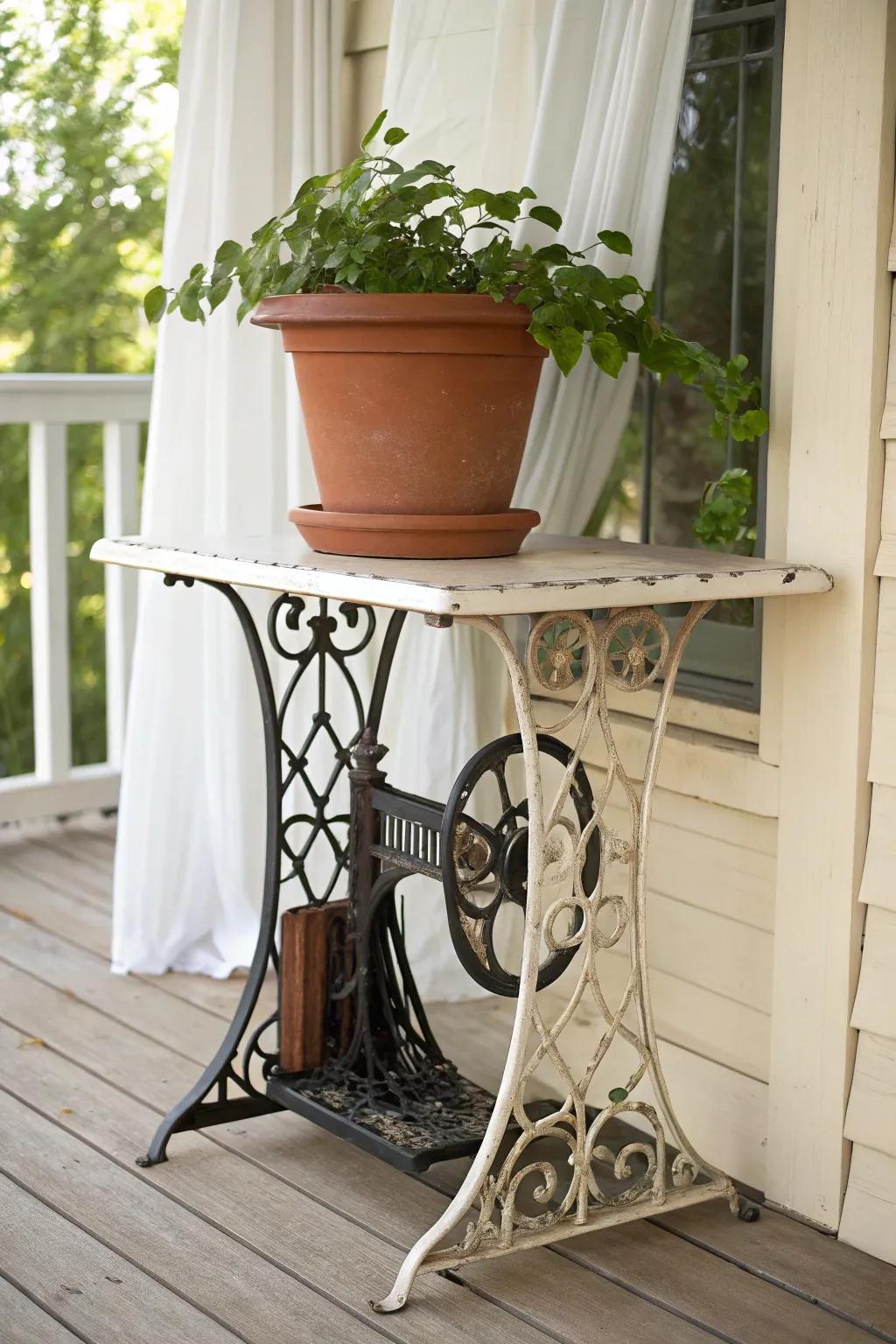 Old treadle sewing table turned plant stand—terracotta + trailing greens for porch charm.