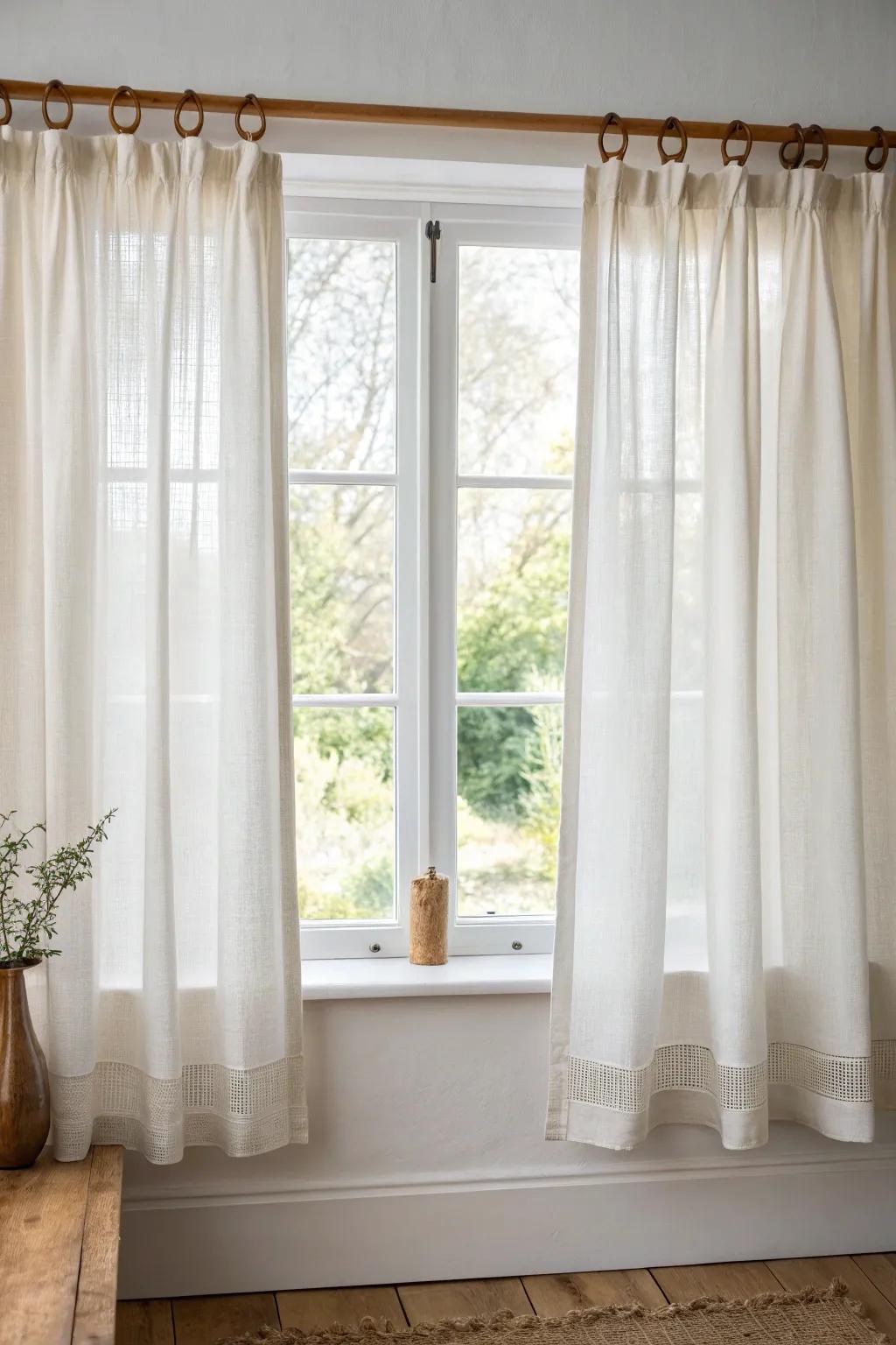 Soft cafe curtains on a slim oak rod—privacy below, sunshine above, farmhouse-cozy.